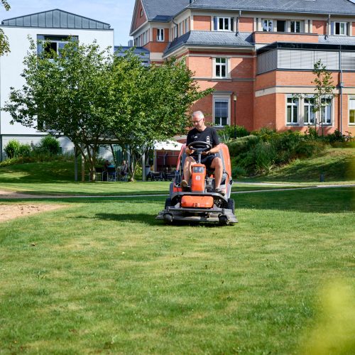 Unser Hausmeister beim Rasenmähen im Klinik-Park
